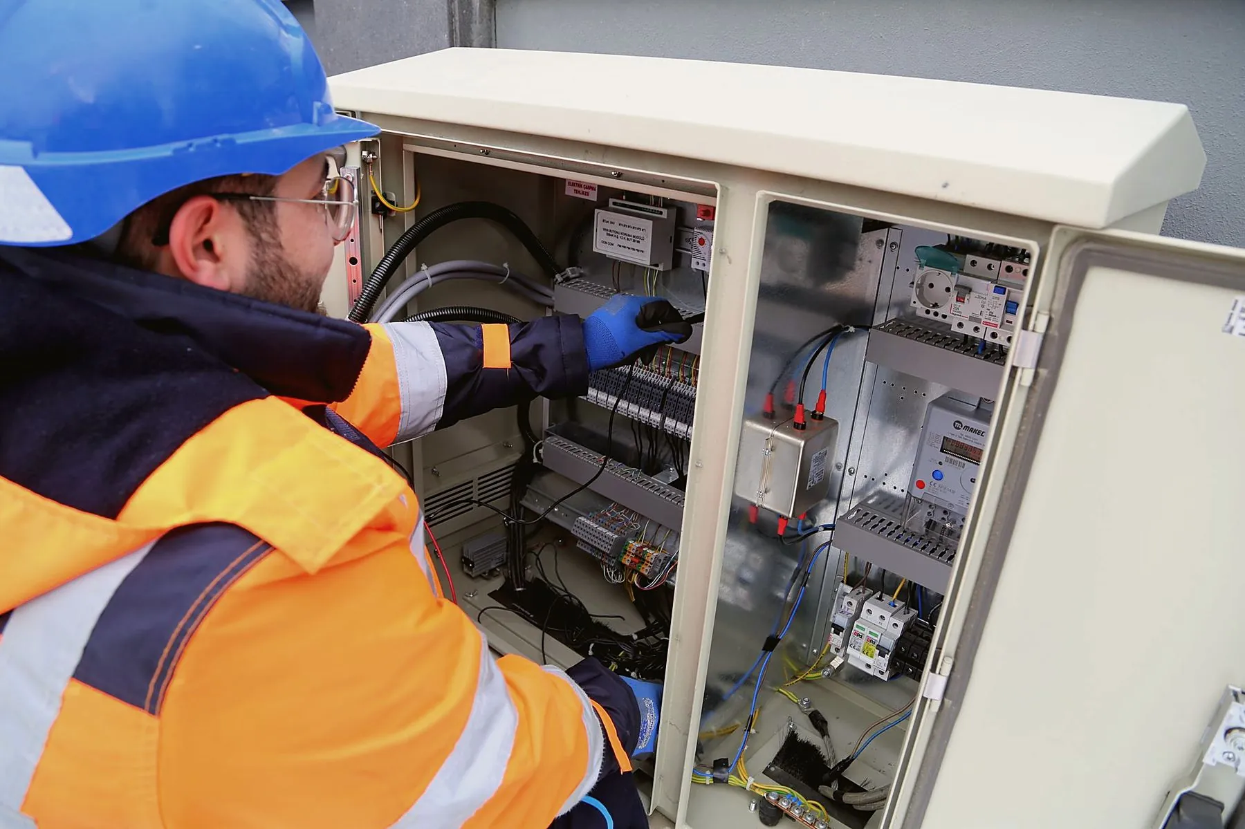 Electrician working inside an outdoor panel
